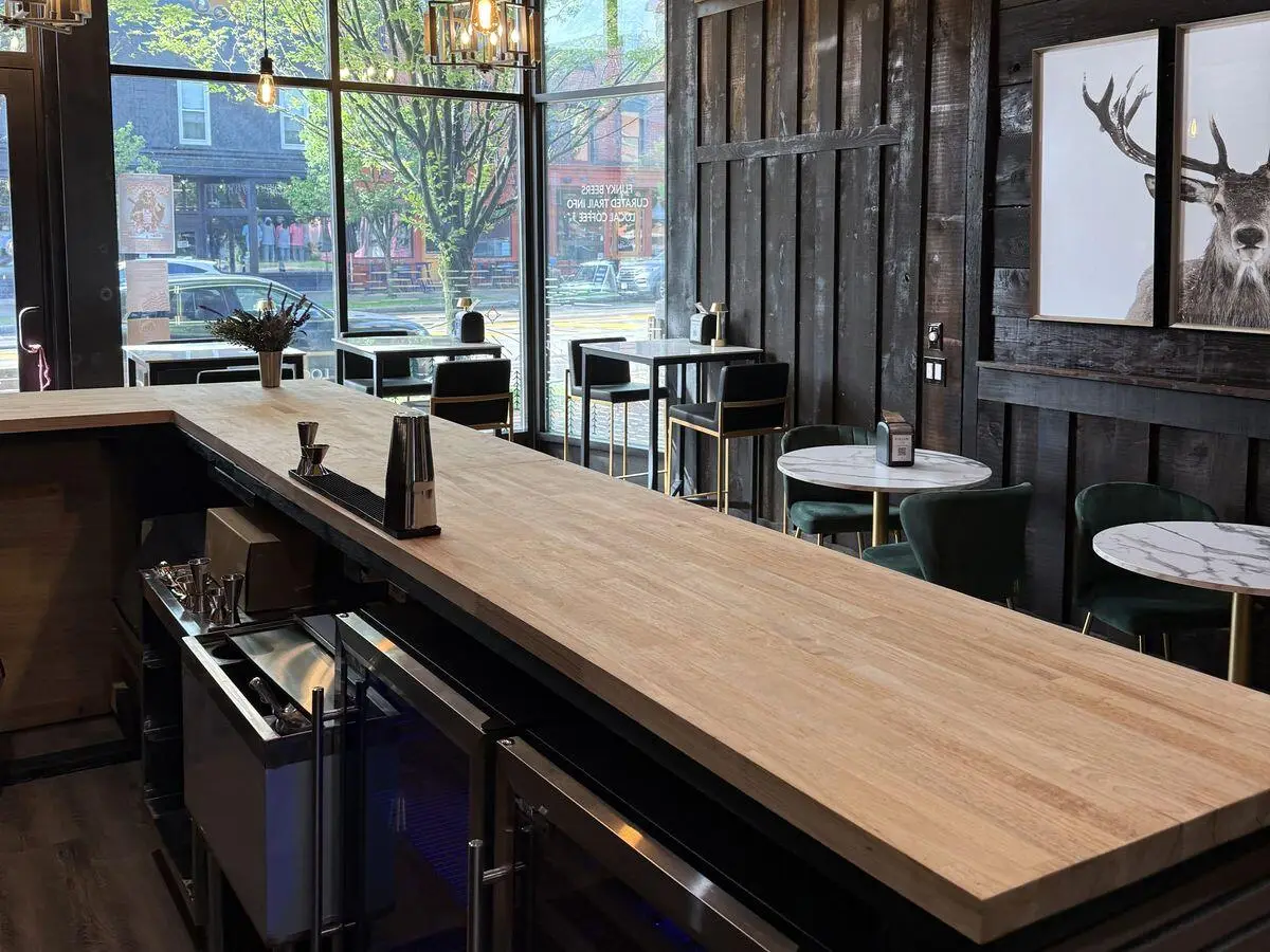 The butcher-block bar counter in The Last Chair, facing the front windows