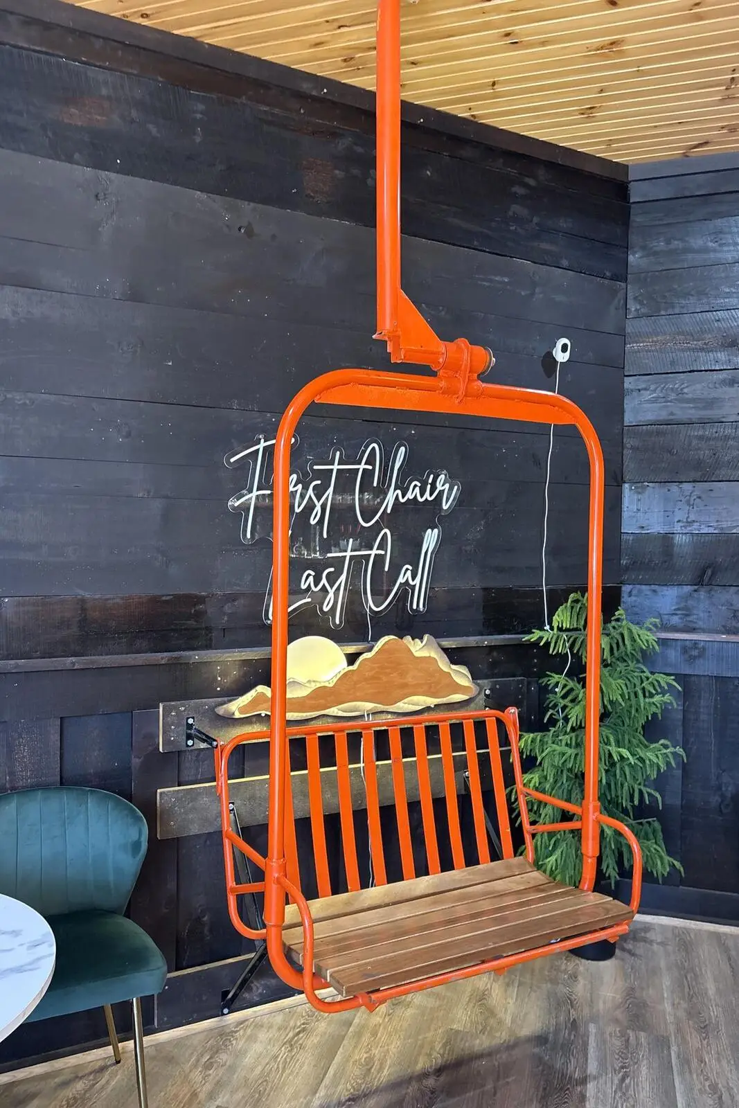 The orange chairlift seat in The Last Chair under a First Chair, Last Call neon sign