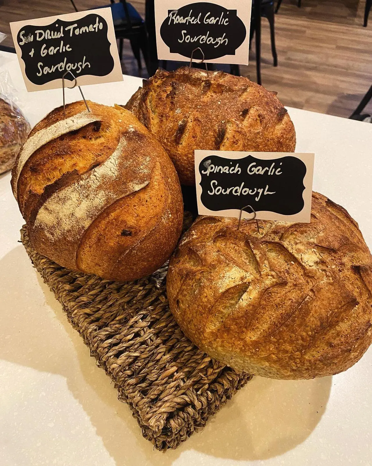 Roasted garlic, spinach garlic and sun-dried tomato sourdough loaves with chalkboard labels