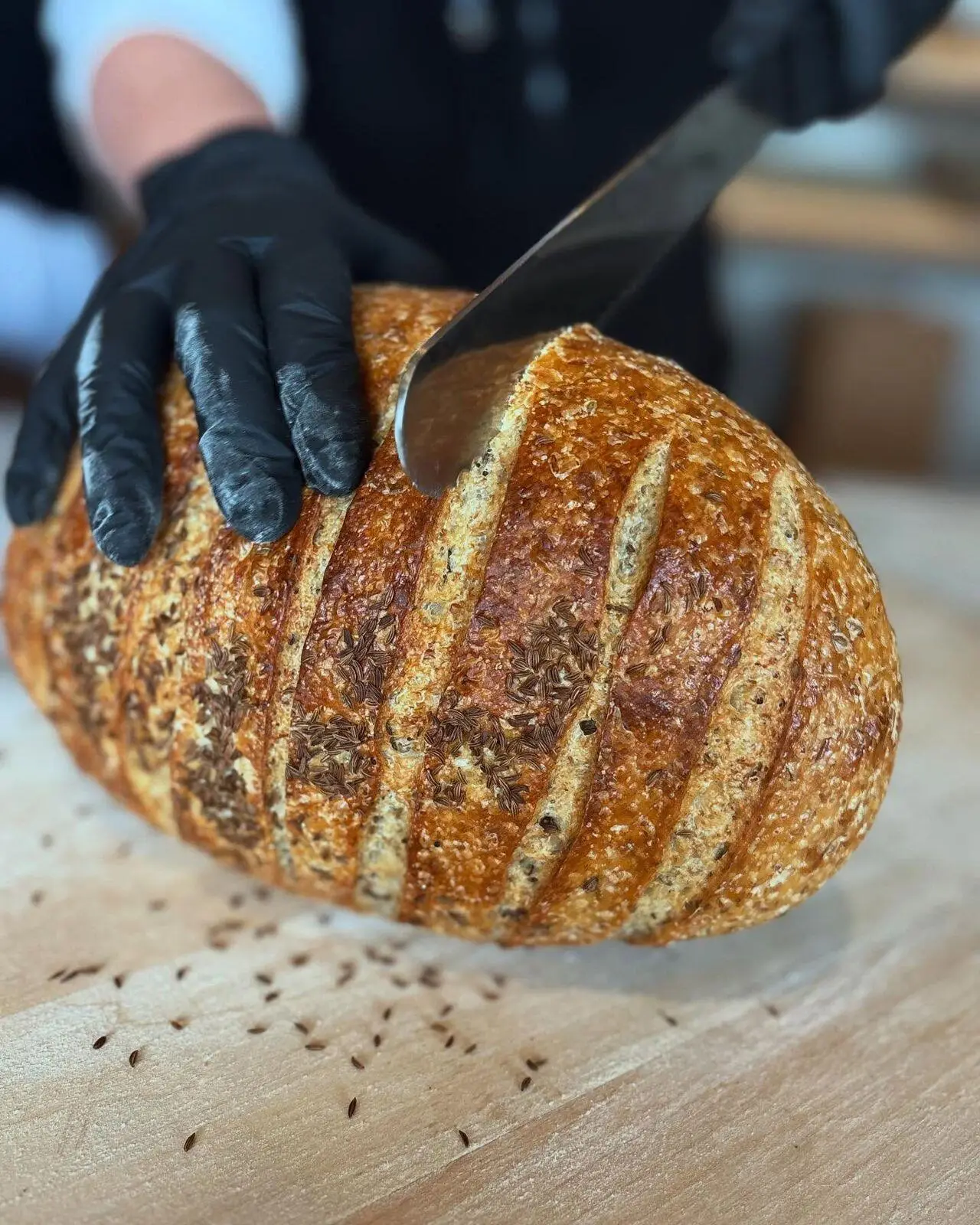 Slicing a seeded sourdough loaf